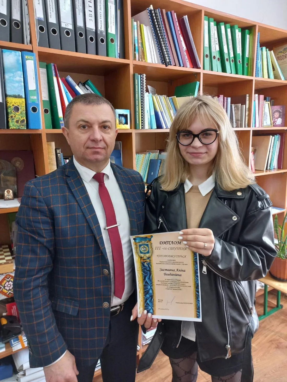 Професор Олег Покотило зі студенткою, яка тримає диплом призерки конкурсу