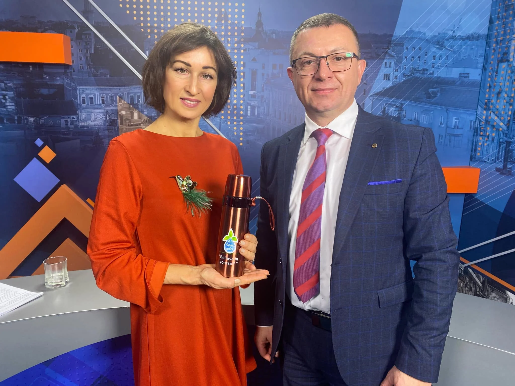 Професор Олег Покотило в телестудії з ведучою, у руках термос-іонізатор Living Water