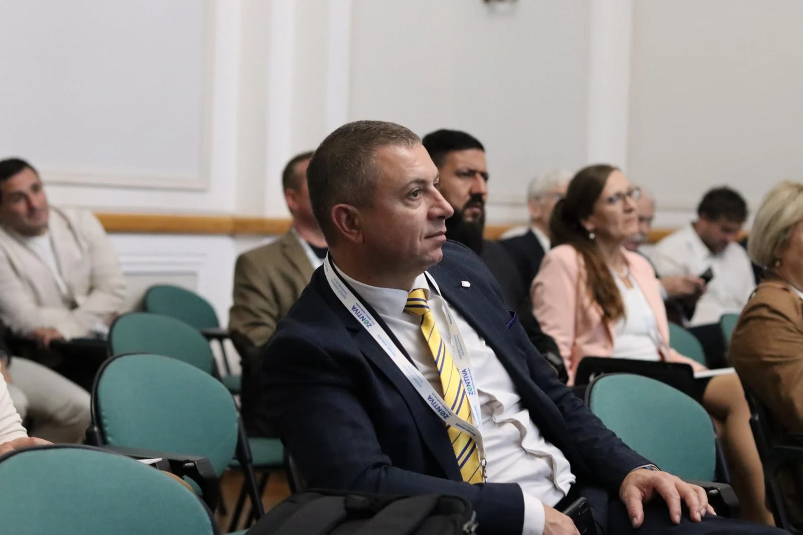 Професор Олег Покотило серед учасників у залі конференції з молекулярного водню